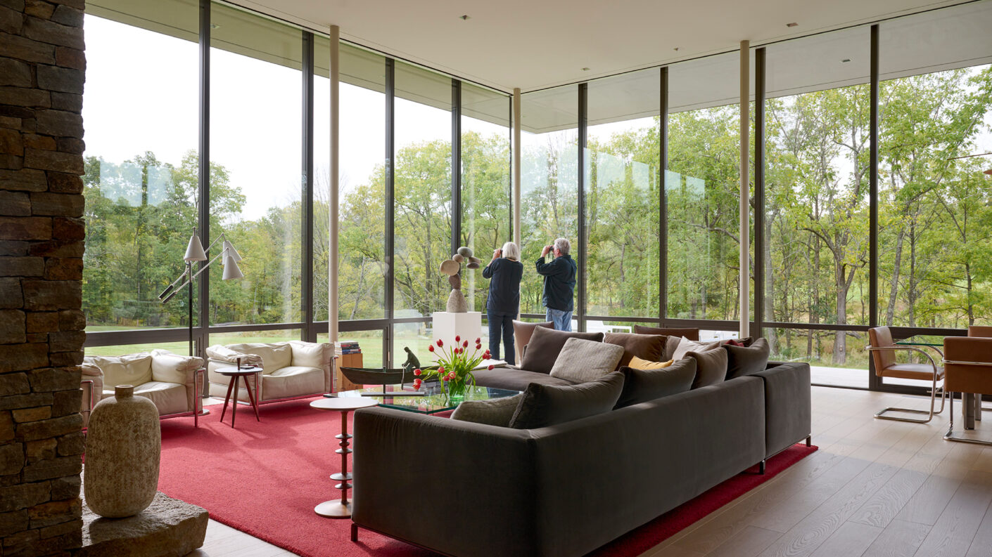 Photo of living room with floor to ceiling views of surrounding landscape. Photo by Jason Schmidt.