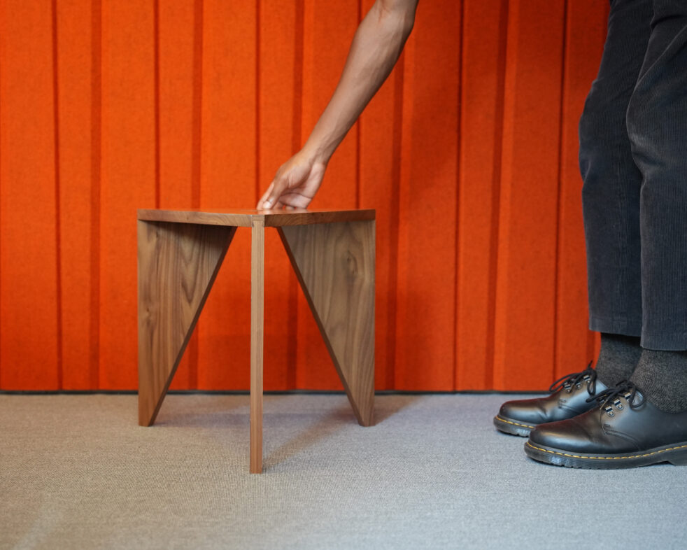 Y-Stool with orange Filzfelt background and hand