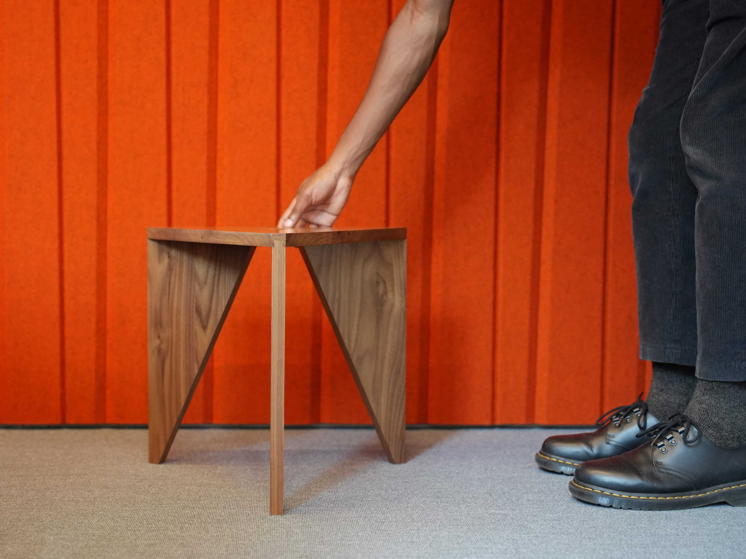 Y-Stool with orange Filzfelt background and hand